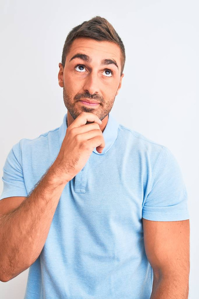 Молодой красивый элегантный мужчина в голубой футболке на изолированном фоне серьезное лицо, думая о вопросе, очень запутанная идея
 - Фото, изображение
