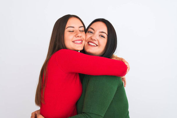 Young beautiful friends smiling happy and confident wearing casual clothes. Standing with a smile on face hugging over isolated white background - Fotó, kép
