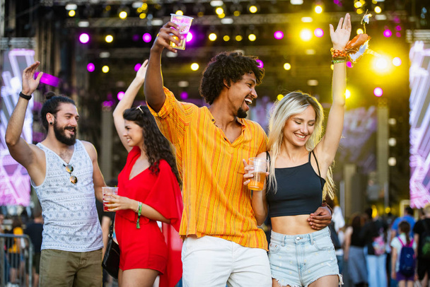 Group of happy friends having fun time at music festival - Photo, image