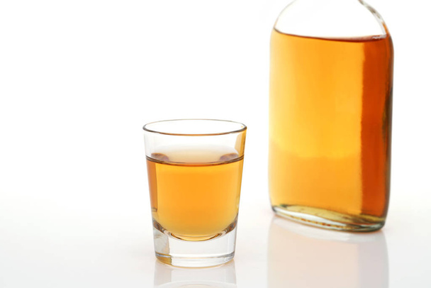 Glasbecher und Flasche Whisky auf weißem Hintergrund - Foto, Bild