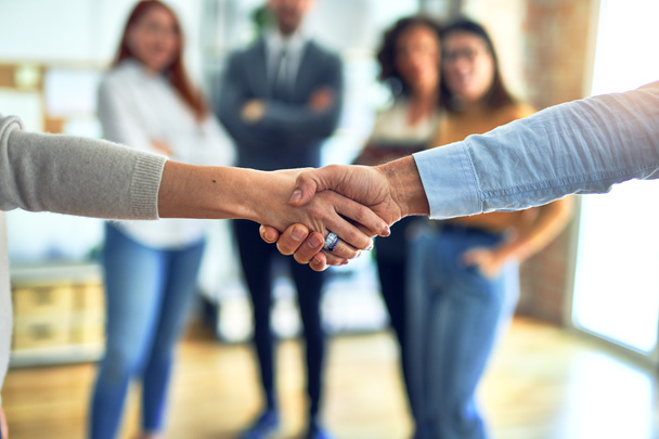 Grupo de empresários de pé juntos apertando as mãos no escritório
 - Foto, Imagem