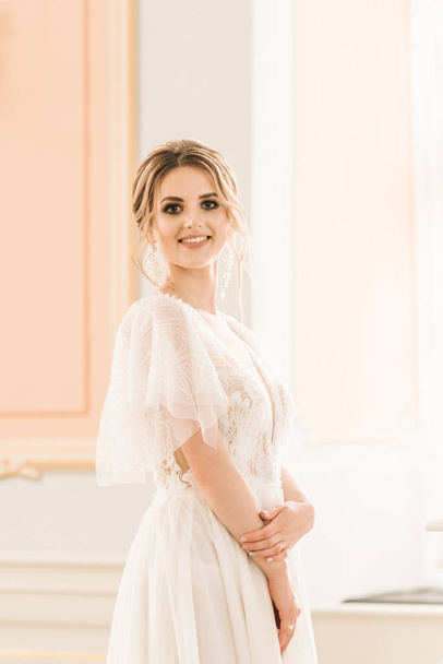 Portrait of a beautiful bride next to a piano in a luxurious interior - Fotó, kép