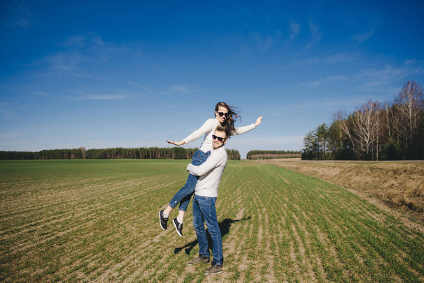 Happy girl and guy running and hugging on the field, love story travel concept, selective focus - Foto, Bild