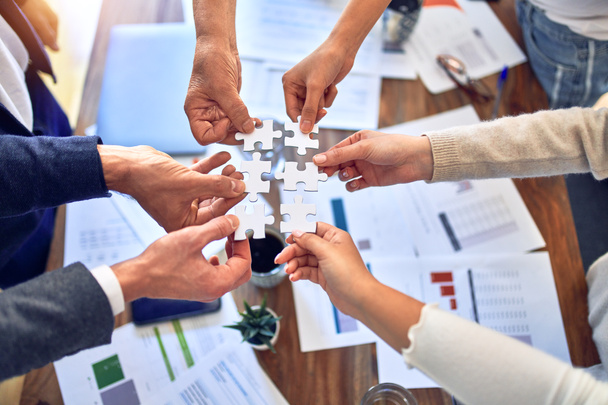 Gruppe von Geschäftsleuten mit Händen, die Puzzleteile im Büro miteinander verbinden - Foto, Bild