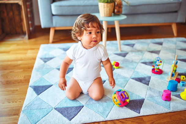 Gyönyörű kisgyermek gyerek lány játszik játékokkal a szőnyegen - Fotó, kép