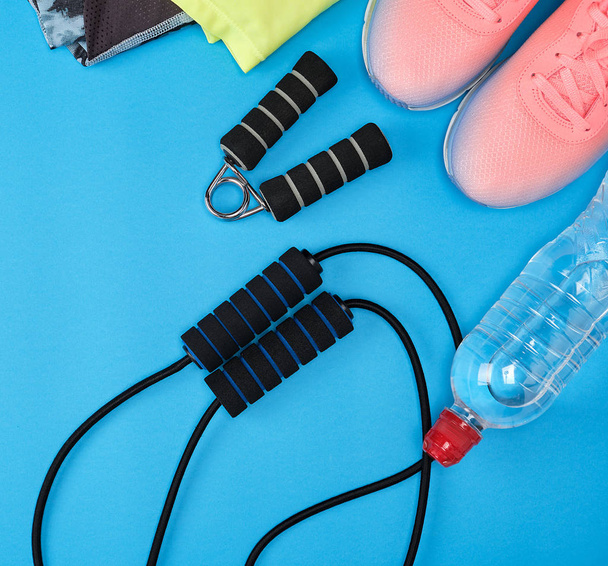 sport textile shoes and other items for fitness on a blue background, top view, copy space - Fotografie, Obrázek