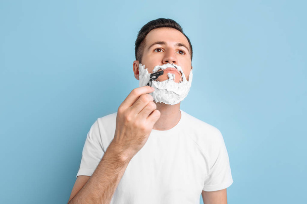 Positive young man with a beard shaves - Foto, immagini
