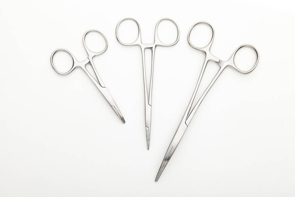 Steel surgical tools and laboratory equipment isolated on a white background. Professional clinic instruments. Medical, surgery, ambulance and veterinarian concept. Closeup with soft selective focus - Valokuva, kuva