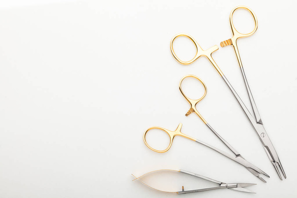 Steel surgical tools and laboratory equipment isolated on a white background. Professional clinic instruments. Medical, surgery, ambulance and veterinarian concept. Closeup with soft selective focus - Фото, изображение