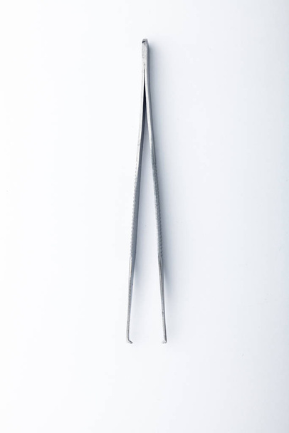 Steel surgical tools and laboratory equipment isolated on a white background. Professional clinic instruments. Medical, surgery, ambulance and veterinarian concept. Closeup with soft selective focus - Photo, image