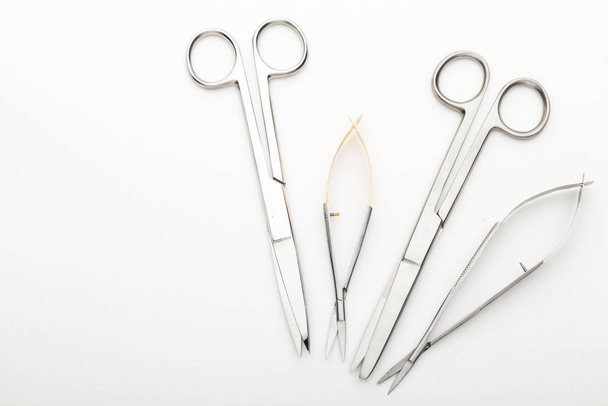 Steel surgical tools and laboratory equipment isolated on a white background. Professional clinic instruments. Medical, surgery, ambulance and veterinarian concept. Closeup with soft selective focus - Fotó, kép