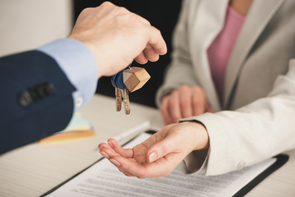 selective focus of realtor giving keys to woman in office  - Photo, Image