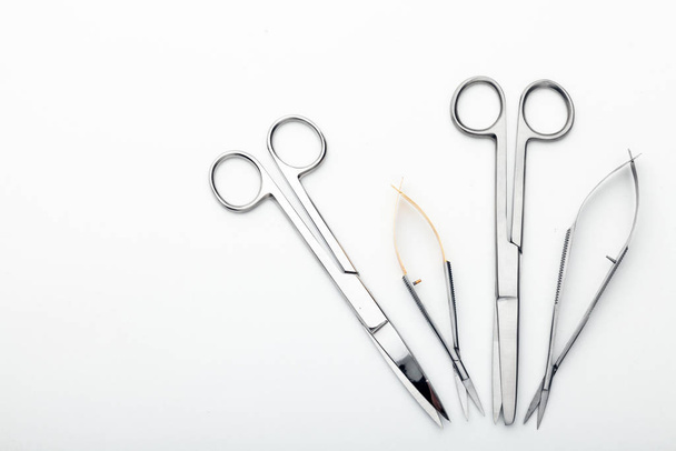 Steel surgical tools and laboratory equipment isolated on a white background. Professional clinic instruments. Medical, surgery, ambulance and veterinarian concept. Closeup with soft selective focus - 写真・画像