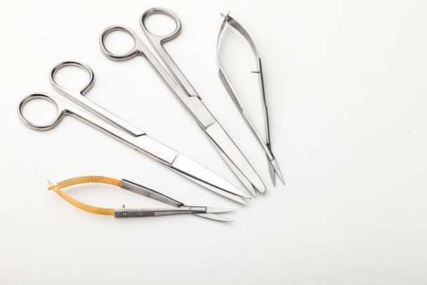 Steel surgical tools and laboratory equipment isolated on a white background. Professional clinic instruments. Medical, surgery, ambulance and veterinarian concept. Closeup with soft selective focus - Photo, image