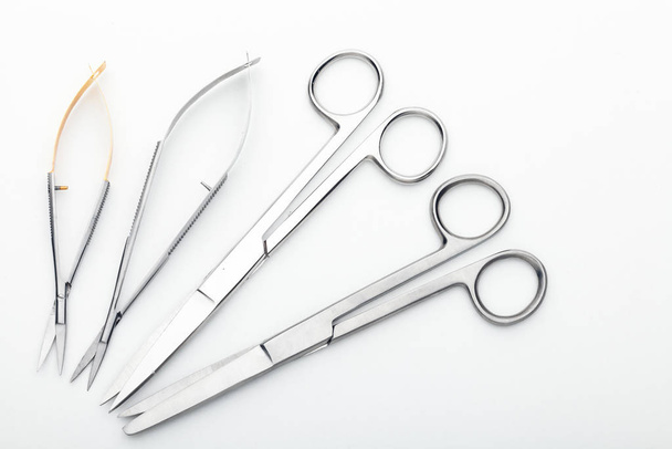 Steel surgical tools and laboratory equipment isolated on a white background. Professional clinic instruments. Medical, surgery, ambulance and veterinarian concept. Closeup with soft selective focus - Φωτογραφία, εικόνα