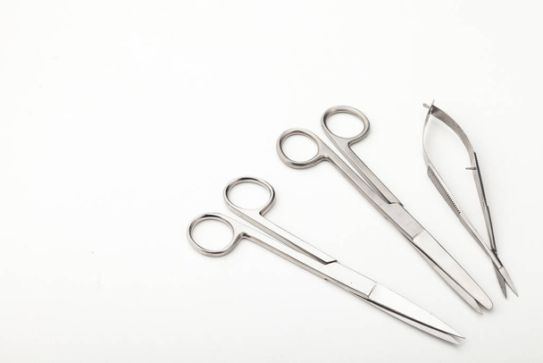 Steel surgical tools and laboratory equipment isolated on a white background. Professional clinic instruments. Medical, surgery, ambulance and veterinarian concept. Closeup with soft selective focus - Foto, imagen