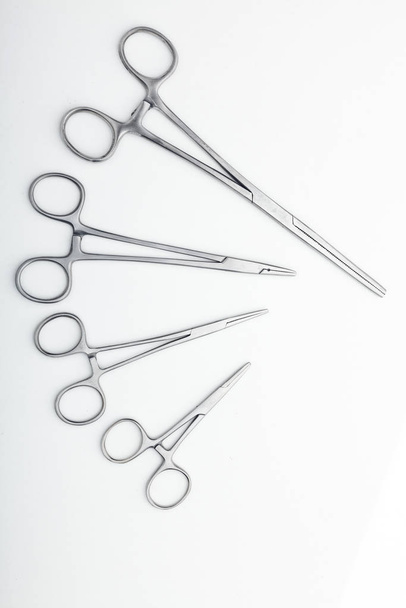 Steel surgical tools and laboratory equipment isolated on a white background. Professional clinic instruments. Medical, surgery, ambulance and veterinarian concept. Closeup with soft selective focus - Foto, immagini