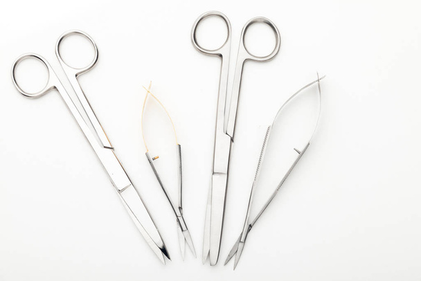Steel surgical tools and laboratory equipment isolated on a white background. Professional clinic instruments. Medical, surgery, ambulance and veterinarian concept. Closeup with soft selective focus - Foto, Imagen