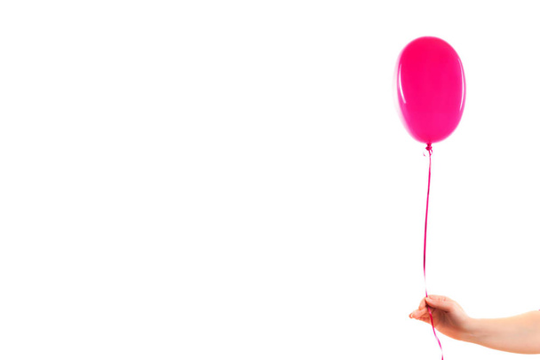 Female hand holds pink rubber inflatable heart shape balloon. Love, relationship, valentines day and birthday celebration concept. Studio shot on an abstract blurred background with blank copy space - Φωτογραφία, εικόνα