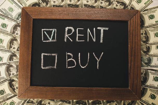 top view of chalkboard with rent and buy lettering near dollar banknotes  - Photo, Image
