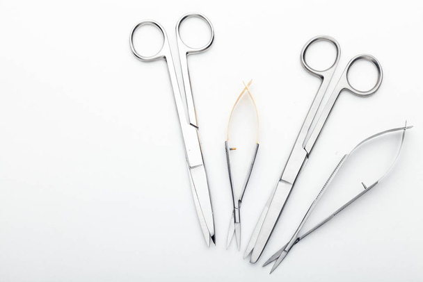 Teräskirurgiset työkalut ja laboratoriolaitteet eristetty valkoisella pohjalla. Ammattiklinikan välineet. Lääketieteen, kirurgian, ambulanssin ja eläinlääkärin käsite. Lähikuva pehmeällä valikoivalla kohdentamisella
 - Valokuva, kuva