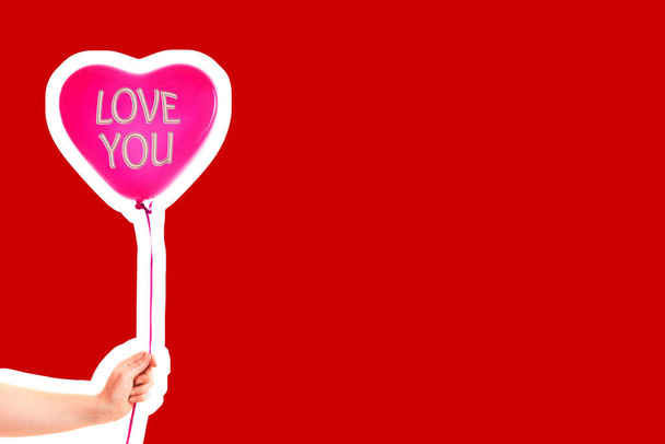 女性の手は赤いゴムインフレータブルハート形の風船を保持します。愛、関係、バレンタインデーと誕生日のお祝いの概念。空白のコピースペースと雑誌スタイルのファッションコラージュ - 写真・画像