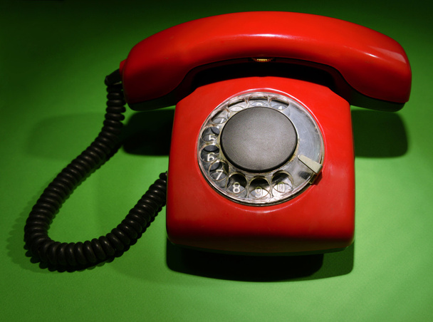 Red retro telephone on dark color background - Foto, afbeelding