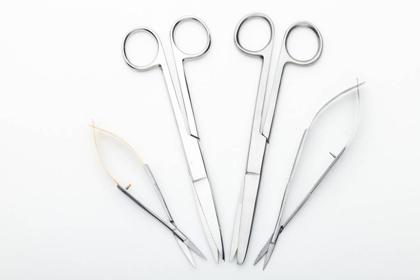 Steel surgical tools and laboratory equipment isolated on a white background. Professional clinic instruments. Medical, surgery, ambulance and veterinarian concept. Closeup with soft selective focus - Fotó, kép
