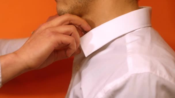 Close-up man probeert knopen op wit shirt vast te maken. Huwelijksdag, nerveuze man gestrest - Video