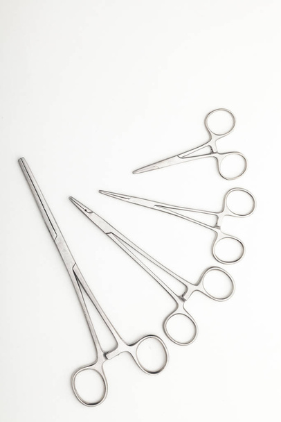 Teräskirurgiset työkalut ja laboratoriolaitteet eristetty valkoisella pohjalla. Ammattiklinikan välineet. Lääketieteen, kirurgian, ambulanssin ja eläinlääkärin käsite. Lähikuva pehmeällä valikoivalla kohdentamisella
 - Valokuva, kuva