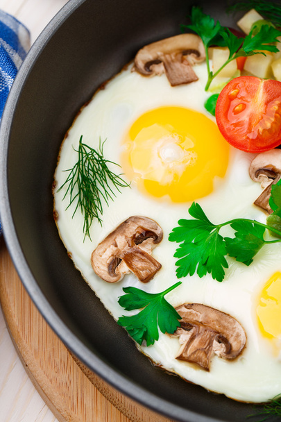Fried eggs in a pan with vegetables - Foto, afbeelding
