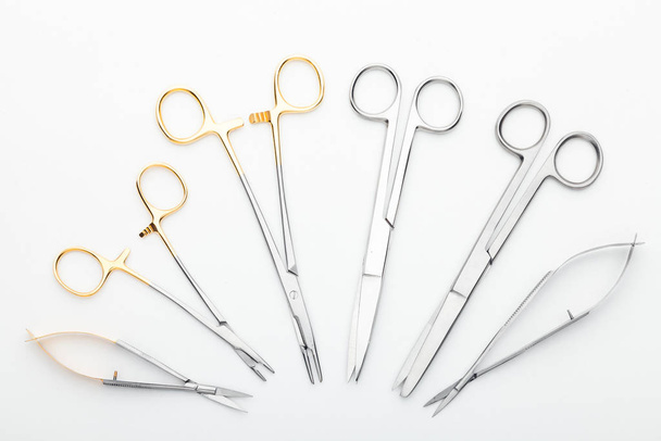 Steel surgical tools and laboratory equipment isolated on a white background. Professional clinic instruments. Medical, surgery, ambulance and veterinarian concept. Closeup with soft selective focus - Photo, Image