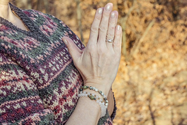 Detal of woman doing namaste hand mudra pose in the forest - Fotó, kép