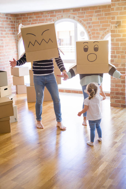 schöne Familie mit Kind, das mit Pappkartons im neuen Zuhause spielt - Foto, Bild