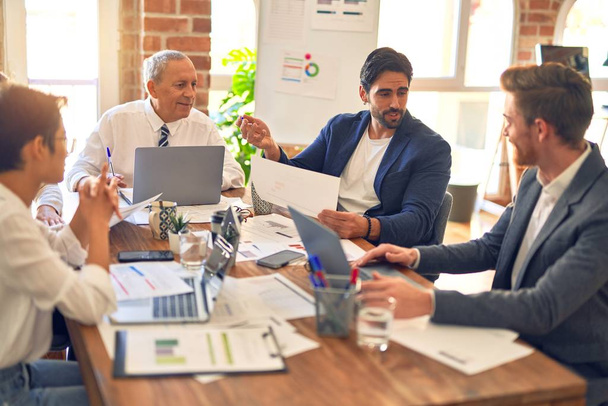 Grupo de empresários que trabalham em conjunto. Sentado na mesa usando documentos de leitura de laptop no escritório
 - Foto, Imagem