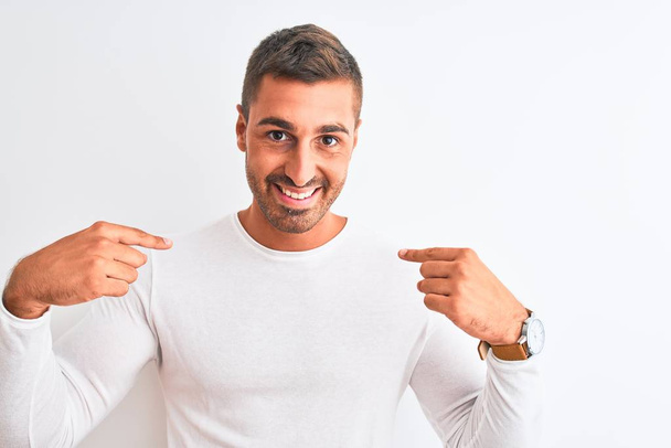 Young handsome man wearing white shirt over isolated background looking confident with smile on face, pointing oneself with fingers proud and happy. - Foto, imagen