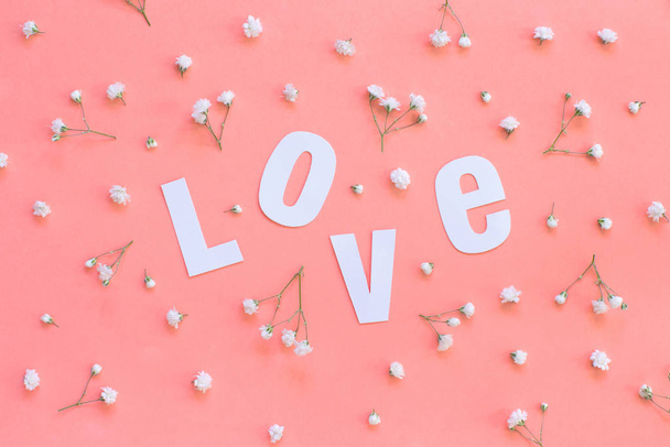 Kukat ja LOVE kirjoitus vaalean vaaleanpunainen tausta
 - Valokuva, kuva
