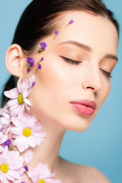 woman with flowers and closed eyes isolated on blue  - Foto, imagen