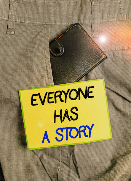 Handwriting text writing Everyone Has A Story. Conceptual photo Background storytelling telling your memories tales Small little wallet inside man trousers front pocket near notation paper - Photo, Image