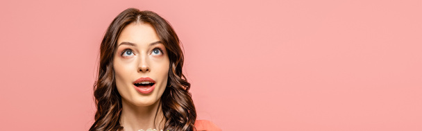 panoramic shot of surprised young woman looking up isolated on pink - Fotoğraf, Görsel