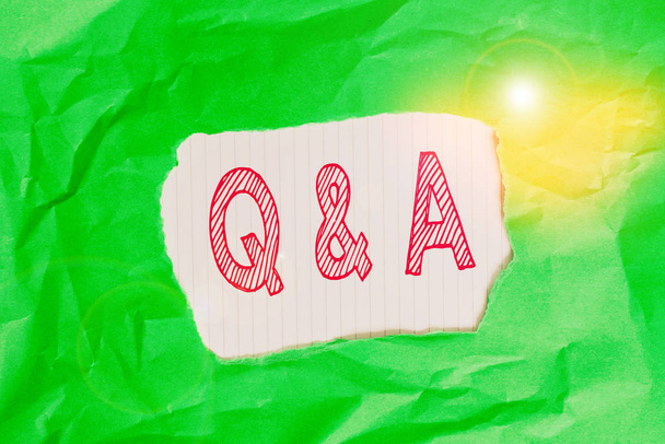 QとA.質問として定義されたビジネスコンセプトを示すメモを書き、緑色の色紙が引き裂かれた背景をくしゃくしゃにした答え - 写真・画像