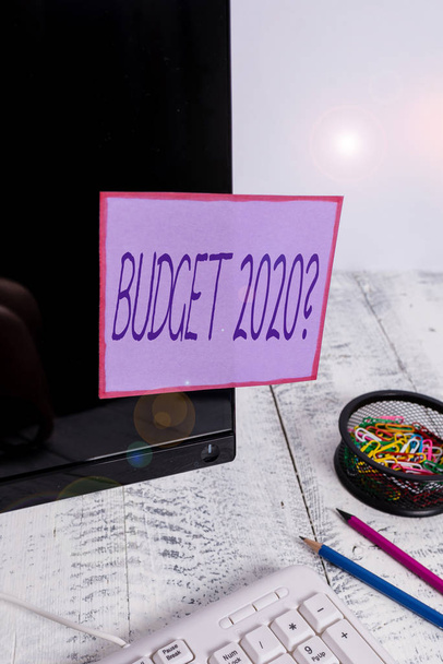 Handwriting text writing Budget 2020 Question. Conceptual photo estimate of income and expenditure for next year Note paper taped to black computer screen near keyboard and stationary - Photo, Image