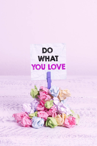 Handwriting text Do What You Love. Conceptual photo Make enjoyable things do activities with motivation Reminder pile colored crumpled paper clothespin reminder white wooden space - Photo, Image