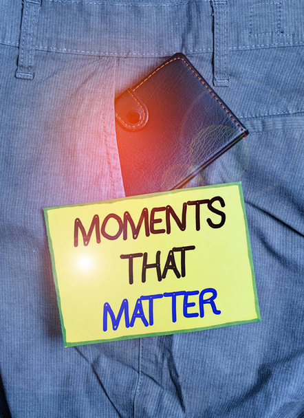 Handwriting text writing Moments That Matter. Conceptual photo Meaningful positive happy memorable important times Small little wallet inside man trousers front pocket near notation paper - Photo, Image