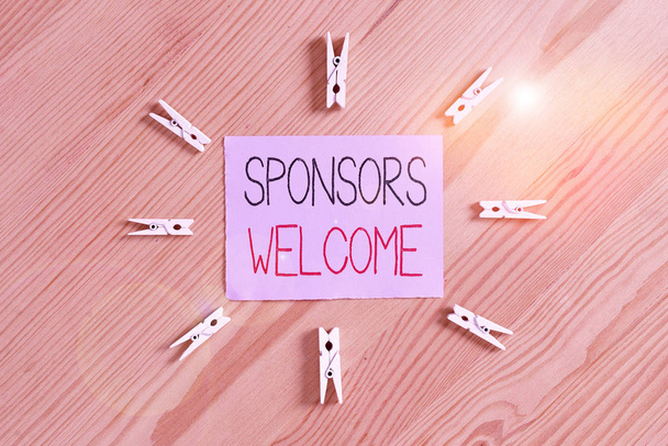 Handwriting text Sponsors Welcome. Conceptual photo greet advertiser that supports a business or individual Colored clothespin papers empty reminder wooden floor background office - Photo, Image