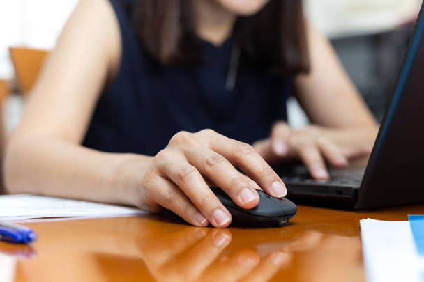 Femme d'affaires clic à la main souris travaillant avec un ordinateur portable
. - Photo, image