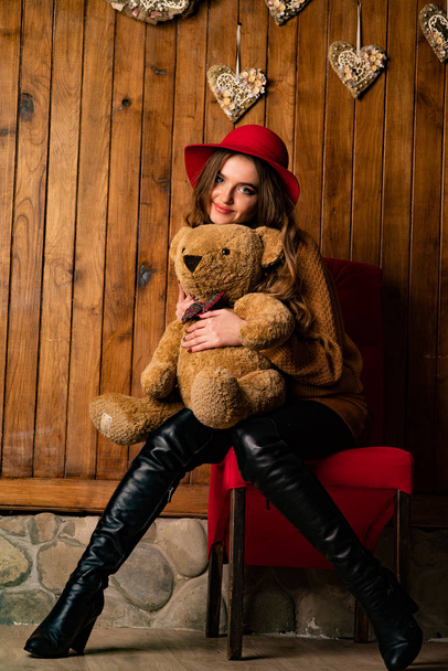 bela morena mulher com brinquedo urso posando em madeira estúdio   - Foto, Imagem