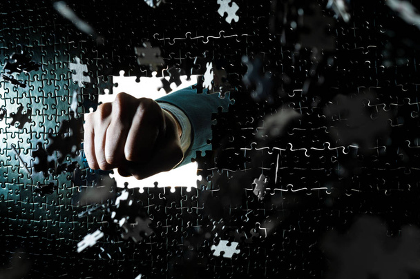 Правая рука человека пробивает головоломку
 - Фото, изображение