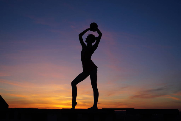 danser in de dans doet de splits in de lucht tegen de zonsondergang / - Foto, afbeelding