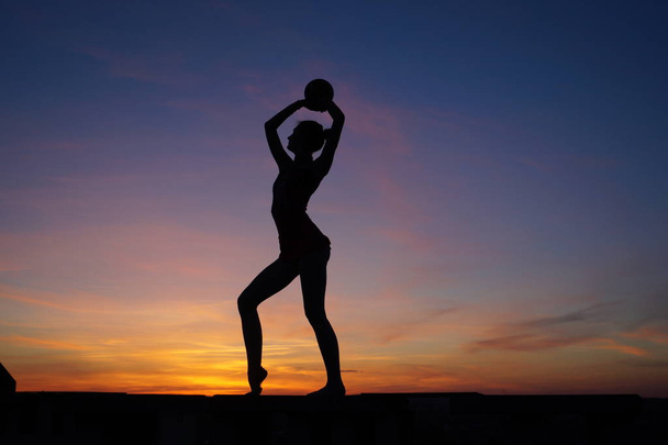 tanssija tanssii tekee halkeamia ilmassa vastaan auringonlasku / - Valokuva, kuva